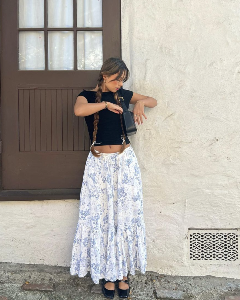 A black crop top and a long floral skirt combine for a stylish, relaxed outfit perfect for beach festivals or casual boardwalk days.